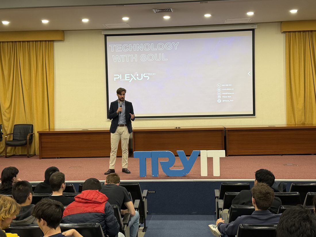 David Fernández Rodríguez on stage at the Try It! UPM conference, next to the event's TRY IT sign, with the audience seated in front